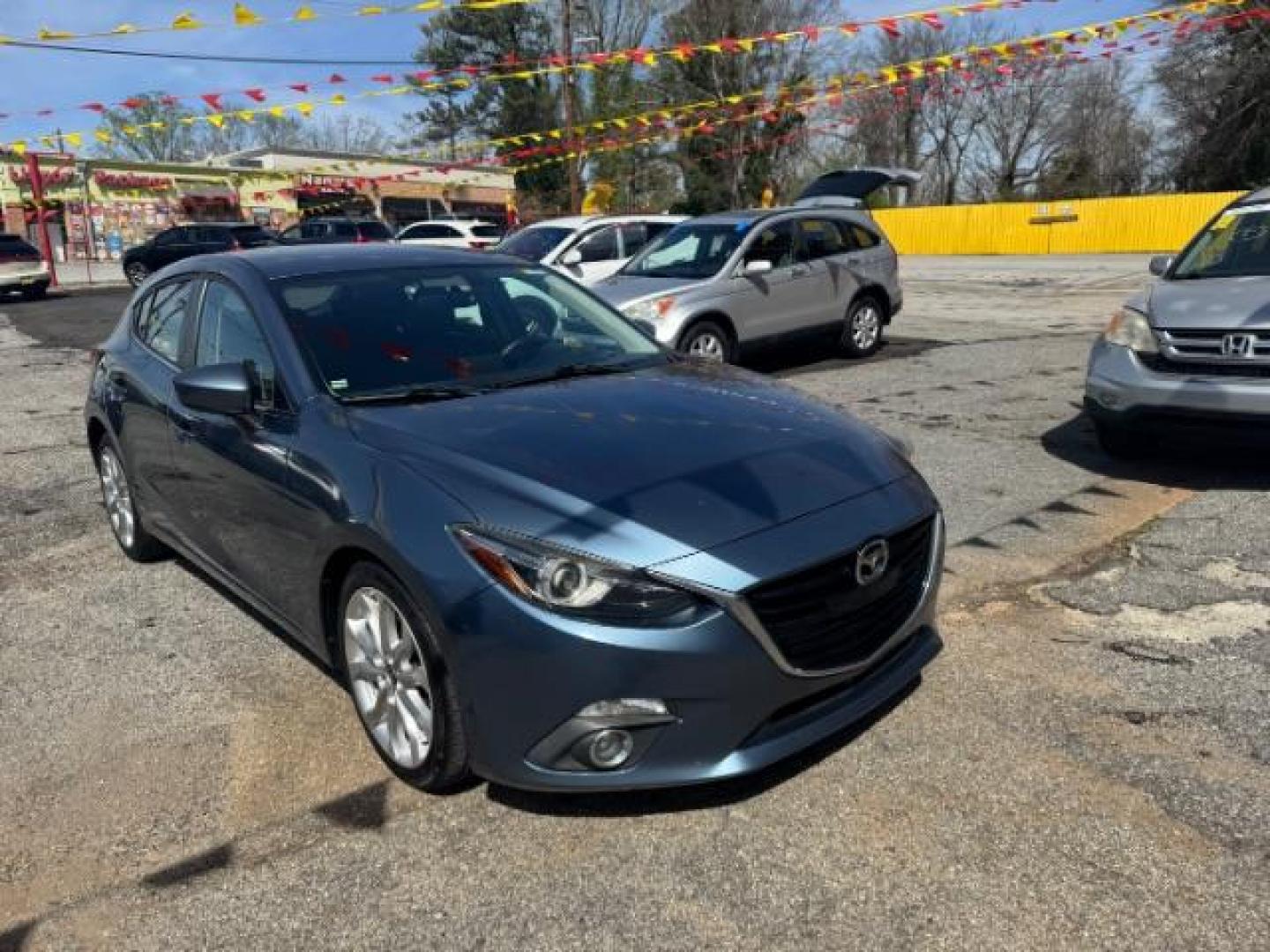 2014 Blue Mazda Mazda3 Hatchback s Touring (JM1BM1L3XE1) with an SKYACTIV-G 2.5L I-4 gasoline direct injection engine, located at 1806 Veterans Memorial Hwy SW, Austell, GA, 30168, (770) 944-9558, 33.817959, -84.606987 - Photo#2
